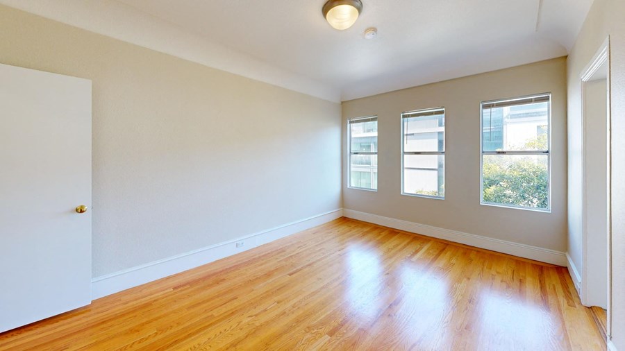 an empty living room with wood floors and white walls